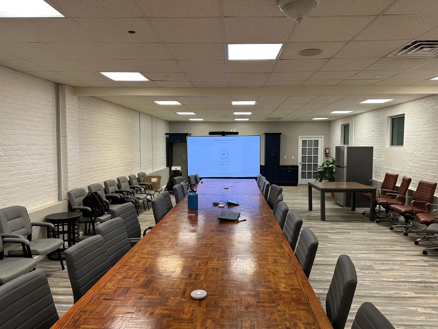 Finished boardroom and training room with a large projector screen, ceiling AV, and conference seating — a NY/NJ design-build buildout