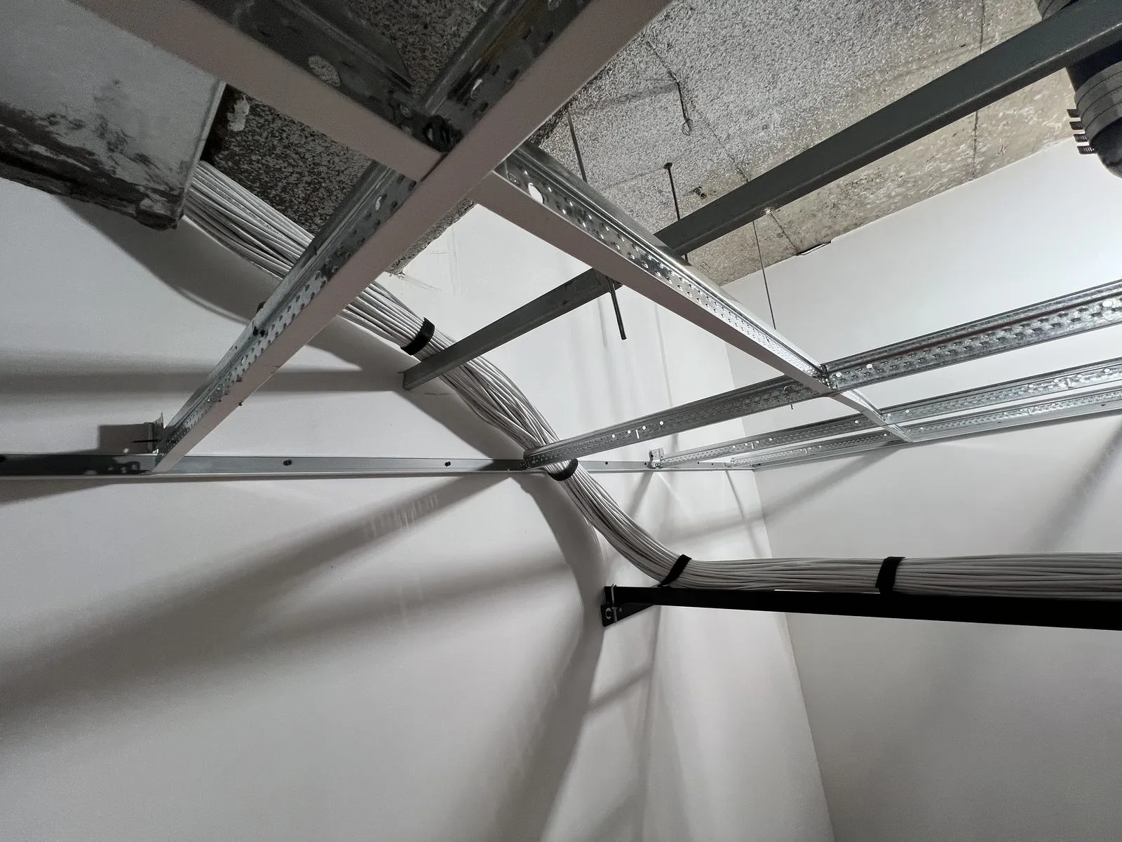 Category cable bundles routed above a ceiling grid during a NY/NJ construction buildout