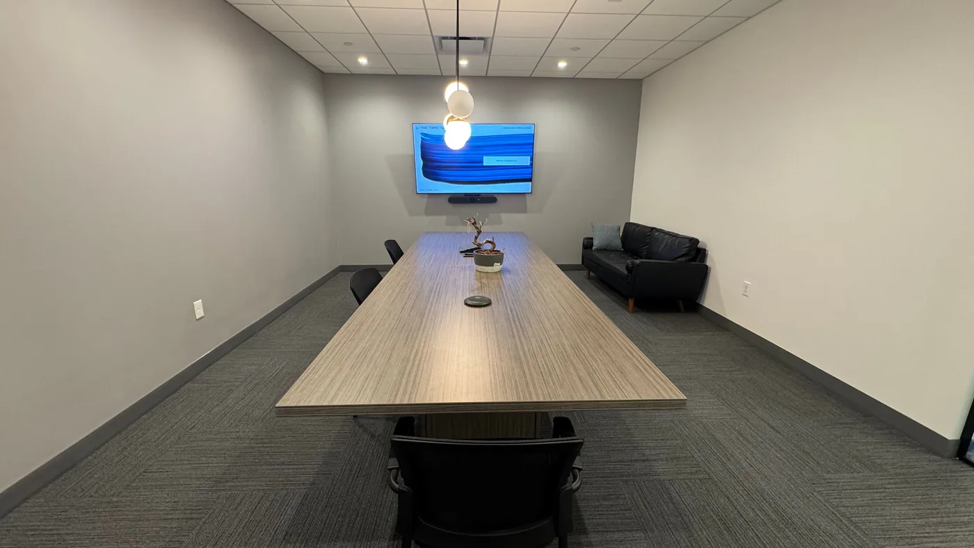 Finished conference room with a wall-mounted display, video bar, and integrated AV installed by Sage Solutions