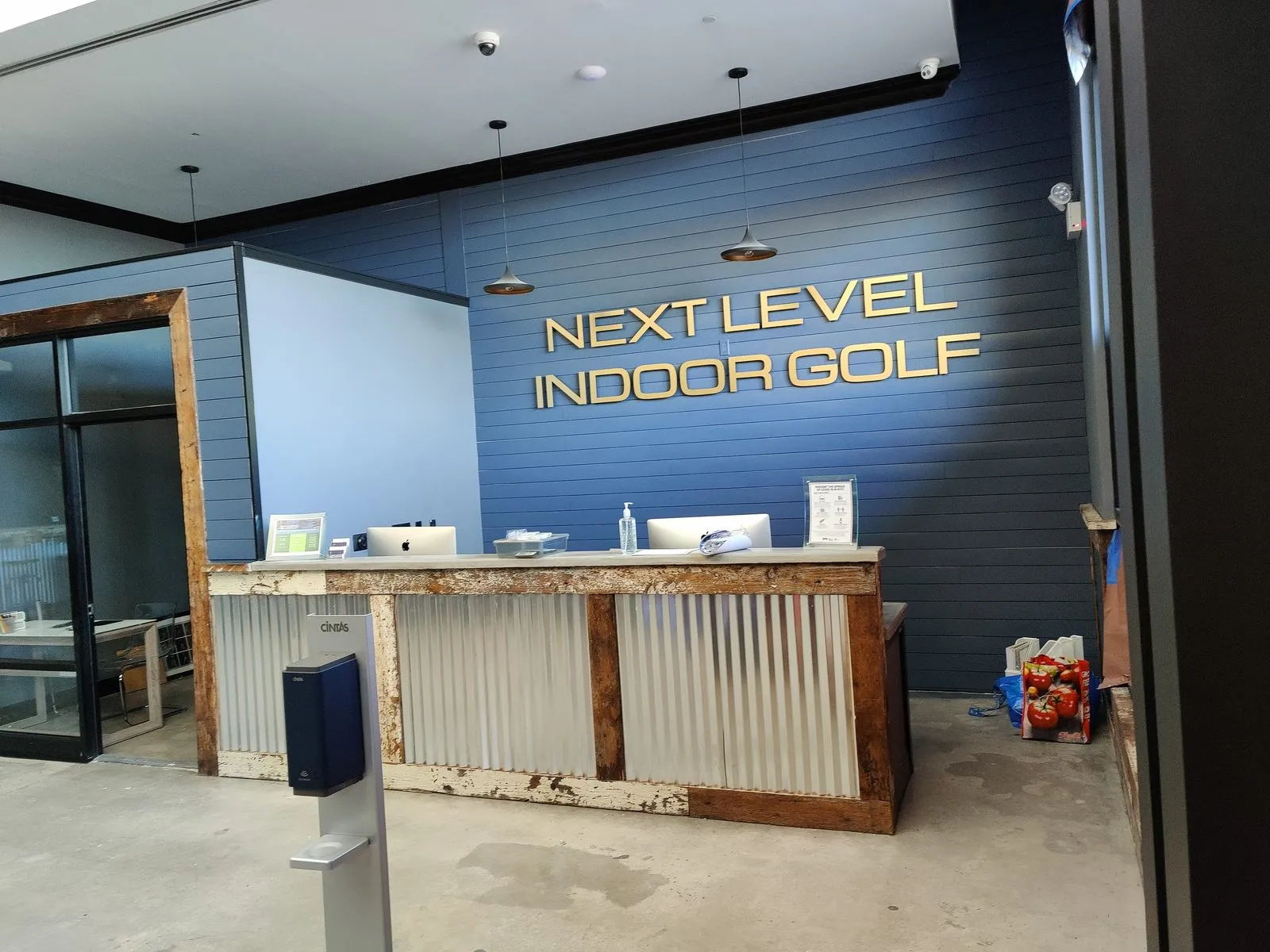 Next Level Indoor Golf — reception area with security cameras, POS, and access control
