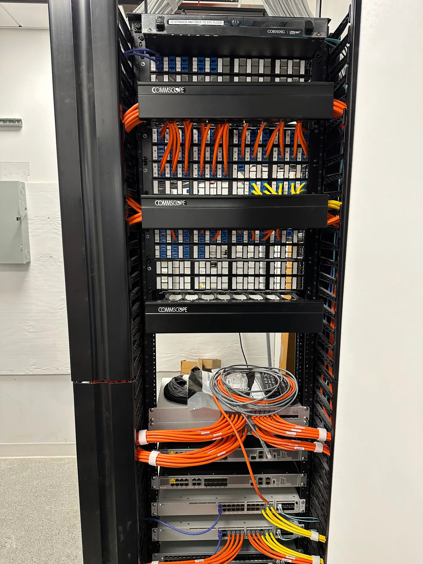 CommScope fiber distribution rack with color-coded jumpers in a server room