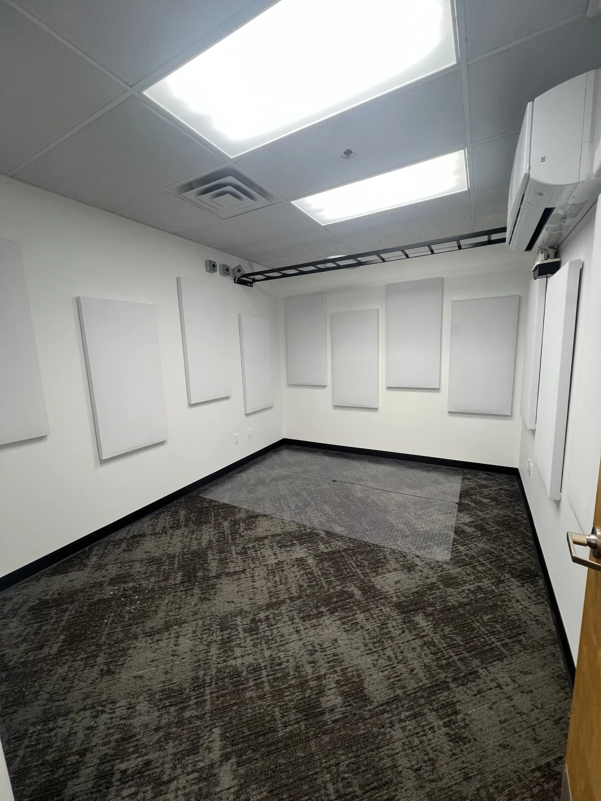 Private home studio with white acoustic wall panels, a ceiling-mounted projector and dedicated cooling