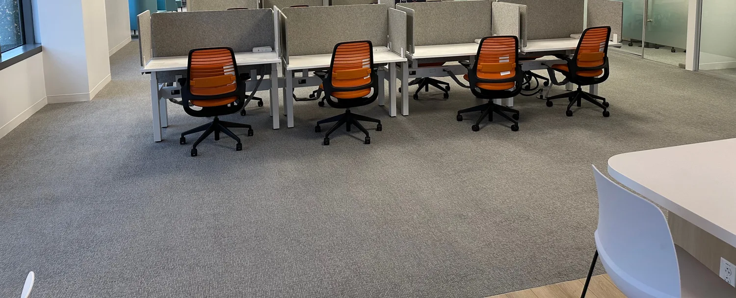 Open office floor after buildout with sit-stand desks, acoustic dividers, and power and data at every seat