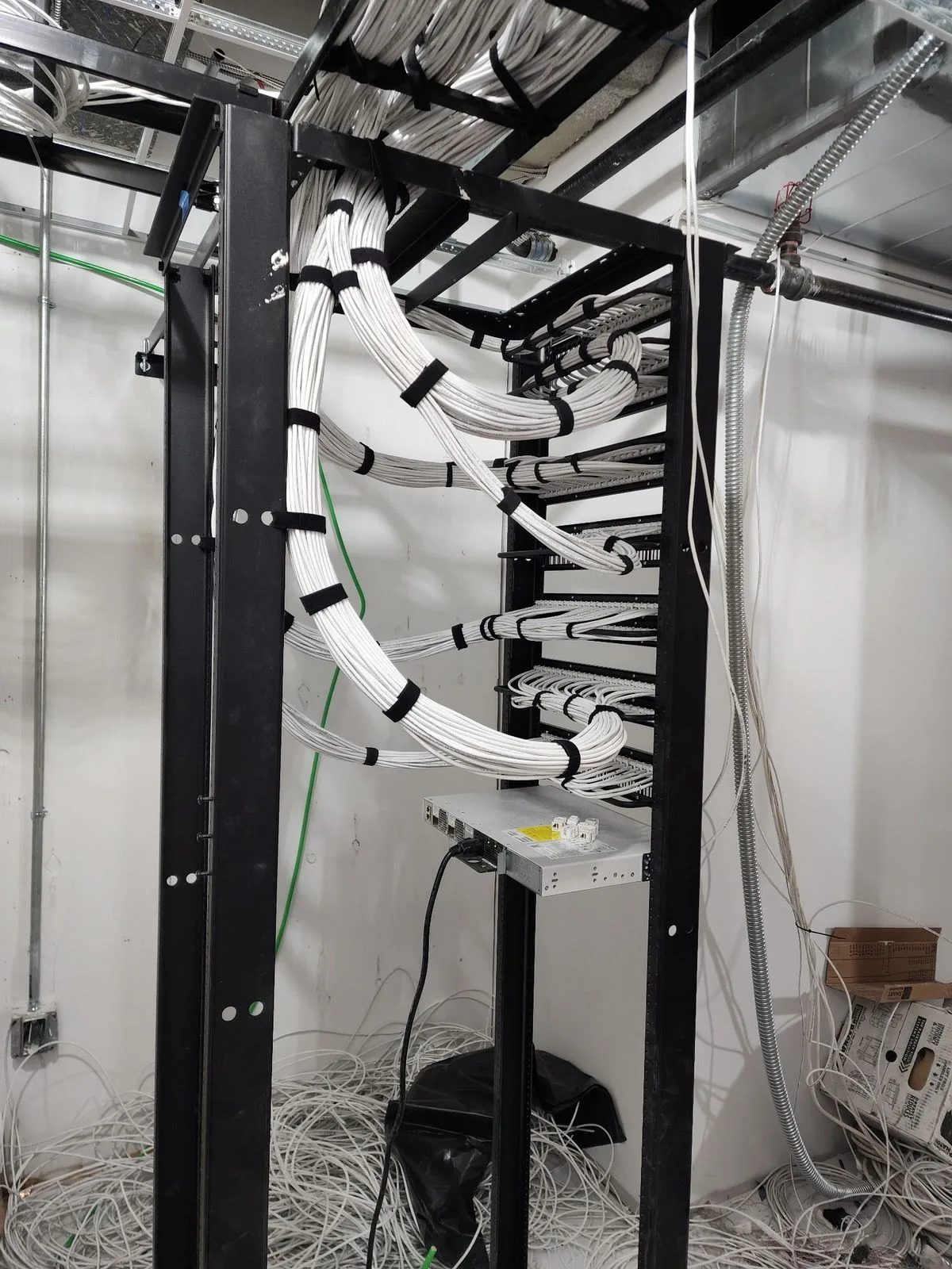 Server room rack with a clean waterfall of category cable into the patch field at a NJ client